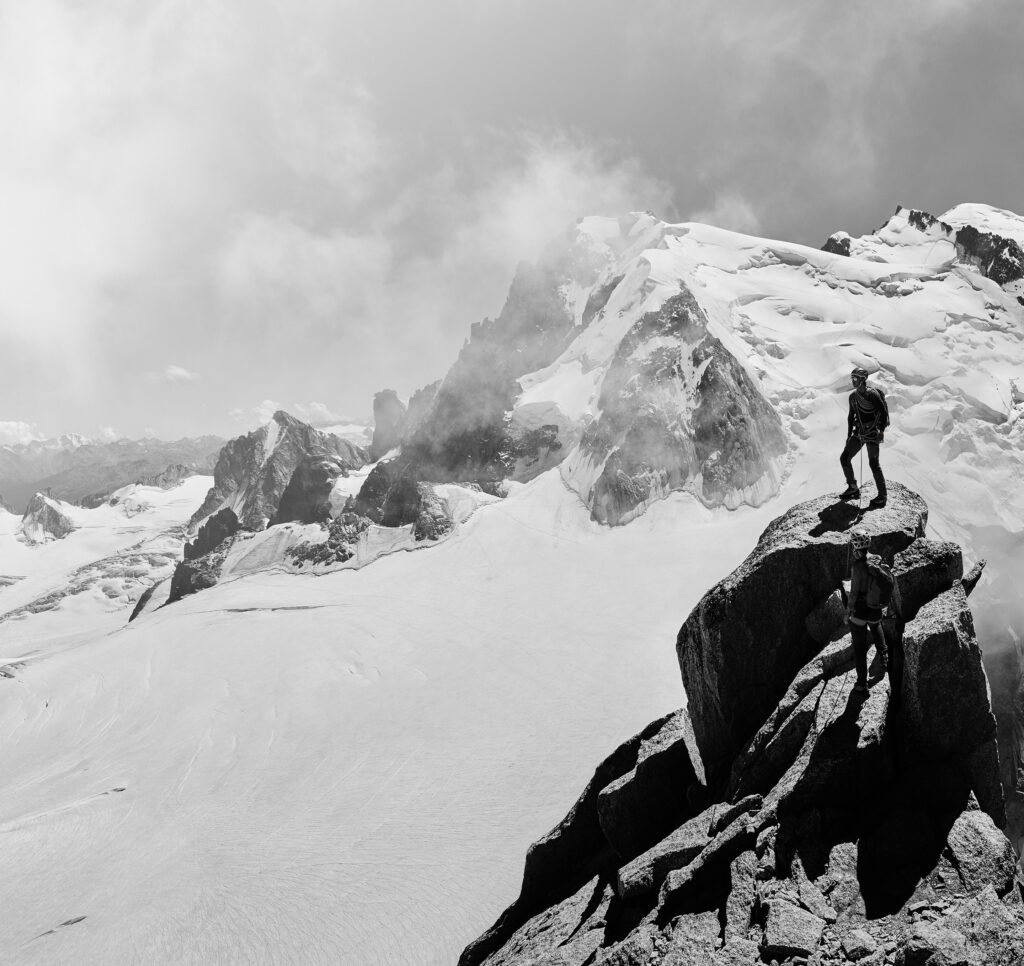 A person standing on top of a mountain amidst the chain